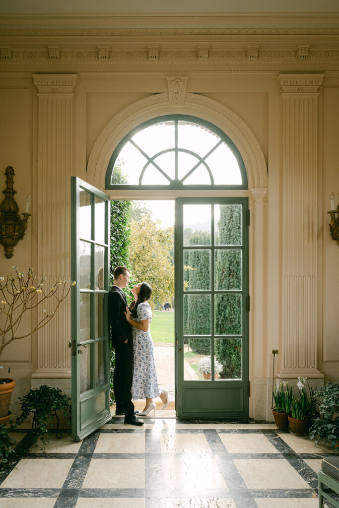 engaged couple kissing in atrium at filoli historic estate and garden