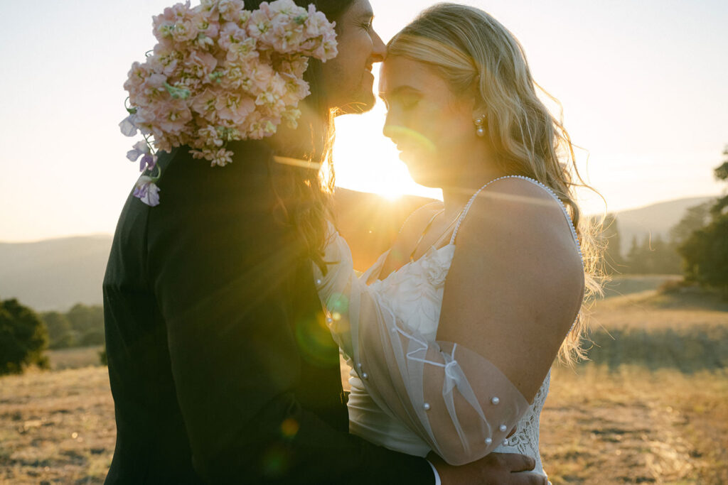 Couple on hisllside as sun streaks through