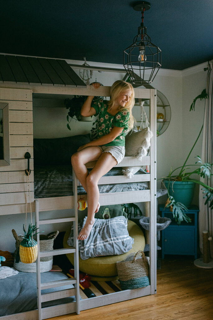 child sitting on bunk bed in bedroom during in-home lifestyle family photography session