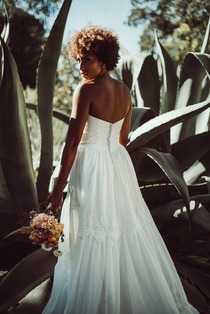 Bride holding her bouquet among aloe plants 