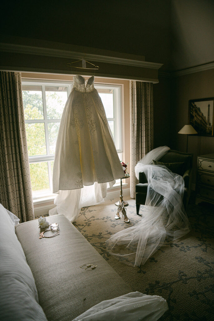 Wedding dress hanging by a window before a wedding